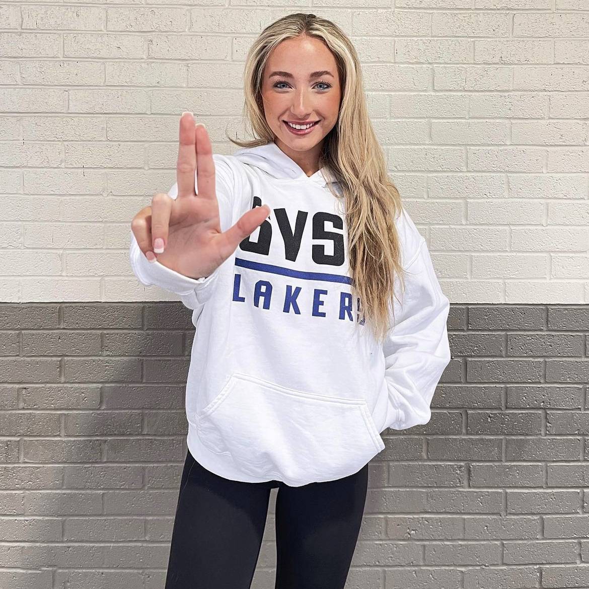 student wearing gvsu sweatshirt holding up the anchor sign